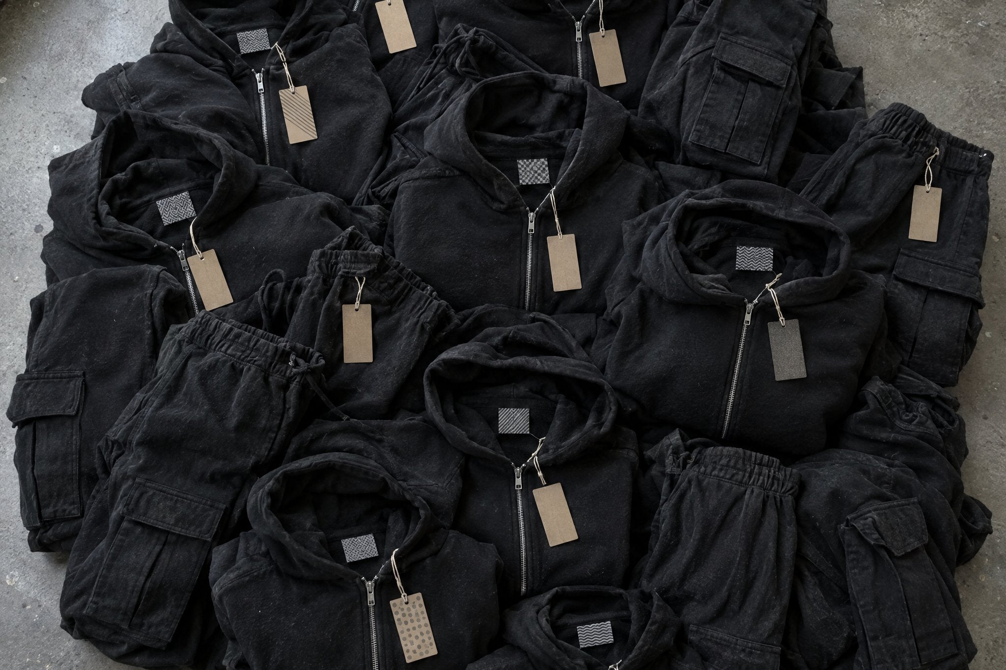 Une pile de hoodies zippés et de cargos noirs presque identiques